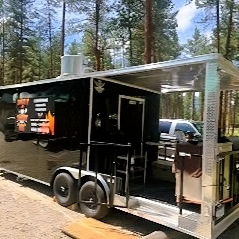 Amaze N' Smokin' BBQ trailer set up in a forest area.