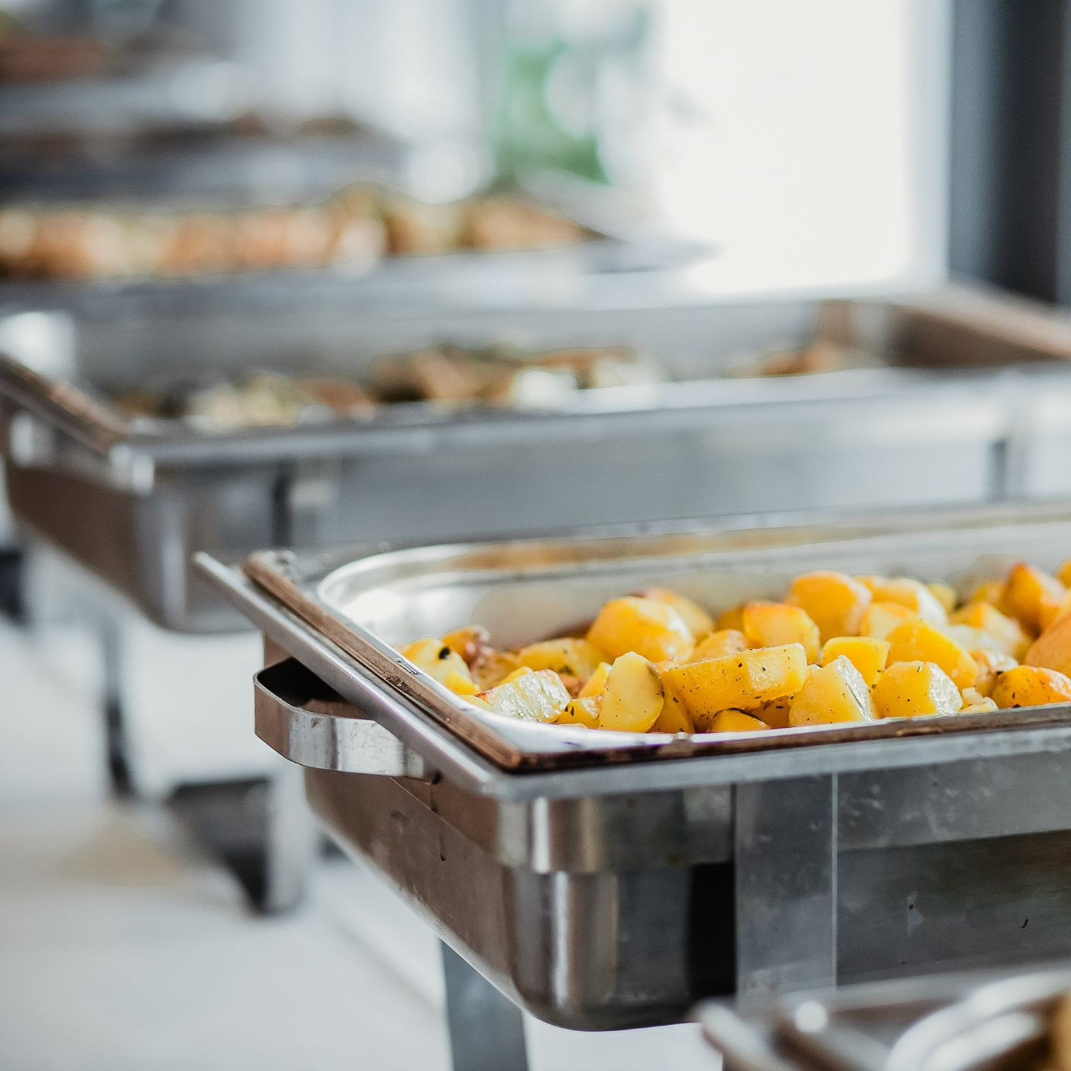 Buffet style catering table with chafers full of vegetables.